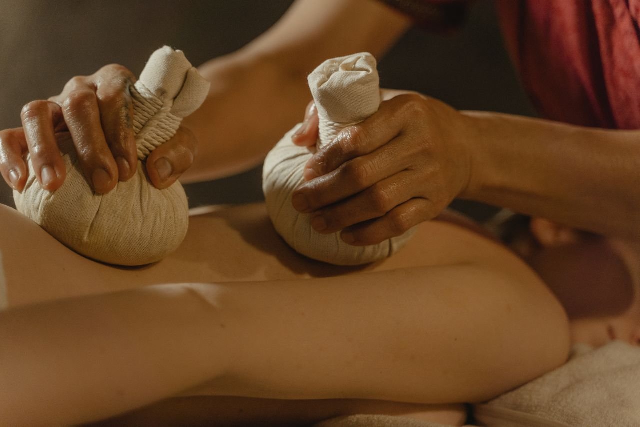 A tranquil scene of an herbal compress massage promoting relaxation and wellness indoors.